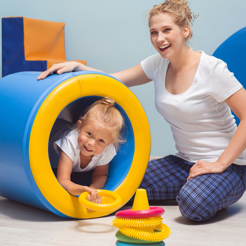 Child exercising with young therapist during occupational therapy